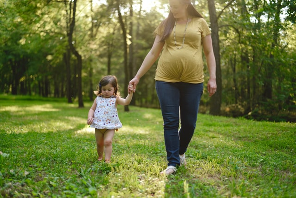 一位怀孕的A卵B怀妈妈带着她年幼的孩子散步